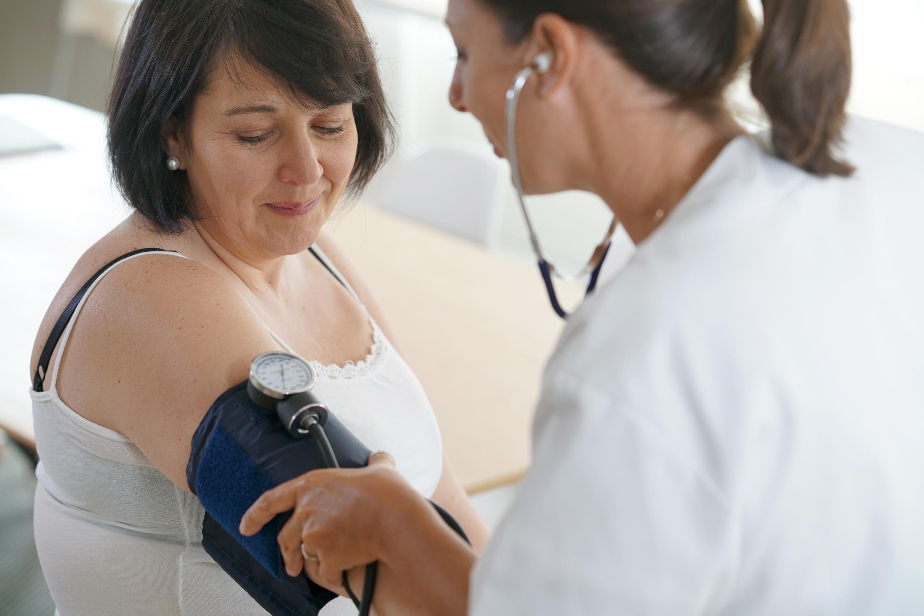 Woman at the doctors having blood pressure taken